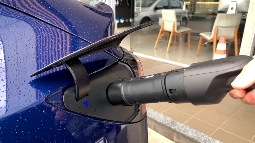Tesla sendo carregado com carregador elétrico